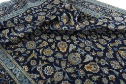 Corner detail of 2000s Kashan rug showing border pattern and Wool pile