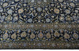 Corner detail of 2000s Kashan rug showing border pattern and Wool pile
