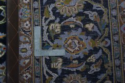 Backside of handmade 2000s Kashan rug showing knot structure and weave density