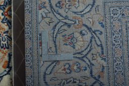 Backside of handmade 2000s Kashan rug showing knot structure and weave density