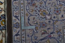 Backside of handmade 2000s Kashan rug showing knot structure and weave density