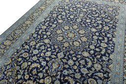 Backside of handmade 2000s Kashan rug showing knot structure and weave density