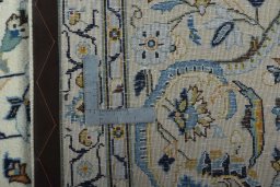 Backside of handmade 2000s Kashan rug showing knot structure and weave density