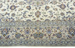 Corner detail of 2000s Kashan rug showing border pattern and Wool pile