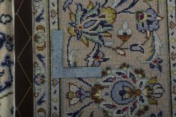 Backside of handmade 2000s Kashan rug showing knot structure and weave density