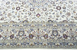Corner detail of 2000s Kashan rug showing border pattern and Wool pile