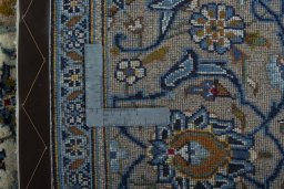 Backside of handmade 2000s Kashan rug showing knot structure and weave density