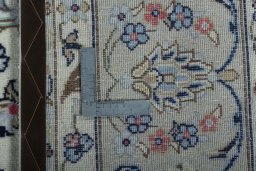 Backside of handmade 2000s Kashan rug showing knot structure and weave density