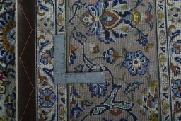 Backside of handmade 2000s Kashan rug showing knot structure and weave density