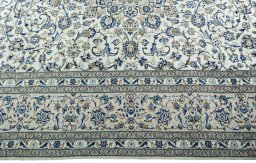Corner detail of 2000s Kashan rug showing border pattern and Wool pile