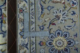 Backside of handmade 2000s Kashan rug showing knot structure and weave density