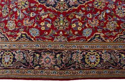 Corner detail of 2000s Kashan rug showing border pattern and Cork pile