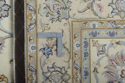 Backside of handmade New Mashad rug showing knot structure and weave density