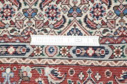 Backside of handmade New Moud rug showing knot structure and weave density