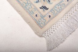 Backside of handmade New Nain rug showing knot structure and weave density