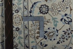 Backside of handmade New Nain rug showing knot structure and weave density