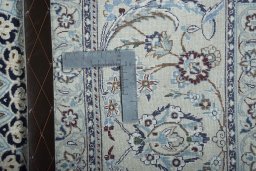Backside of handmade New Nain rug showing knot structure and weave density