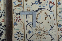 Backside of handmade New Nain rug showing knot structure and weave density
