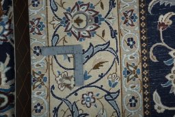 Backside of handmade New Nain rug showing knot structure and weave density