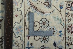 Backside of handmade New Nain rug showing knot structure and weave density