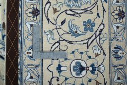 Backside of handmade New Nain rug showing knot structure and weave density