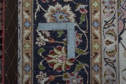 Backside of handmade 2000s Tabriz 50/60/70 Raj rug showing knot structure and weave density