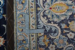 Backside of handmade 2000s Kashan rug showing knot structure and weave density