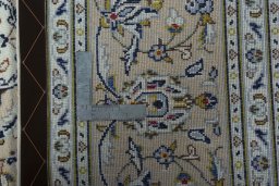 Backside of handmade 2000s Kashan rug showing knot structure and weave density