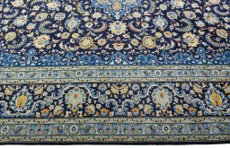 Corner detail of 2000s Kashan rug showing border pattern and Wool pile