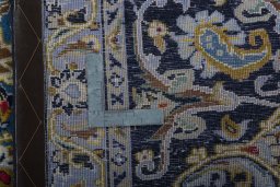 Backside of handmade 2000s Kashan rug showing knot structure and weave density