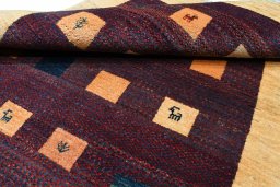 Corner detail of 2000s Persian Gabbeh rug showing border pattern and Wool pile