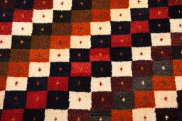 Backside of handmade 2000s Persian Gabbeh rug showing knot structure and weave density