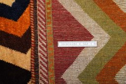 Corner detail of 2000s Persian Gabbeh rug showing border pattern and Wool pile