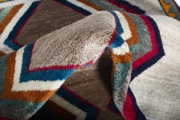 Corner detail of 2000s Persian Gabbeh rug showing border pattern and Wool pile