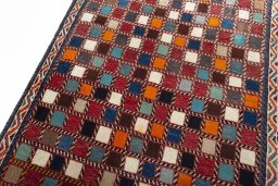 Backside of handmade 2000s Persian Gabbeh rug showing knot structure and weave density