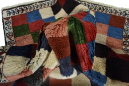 Corner detail of 2000s Persian Gabbeh rug showing border pattern and Wool pile