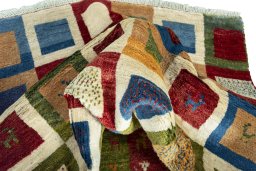 Corner detail of 2000s Persian Gabbeh rug showing border pattern and Wool pile
