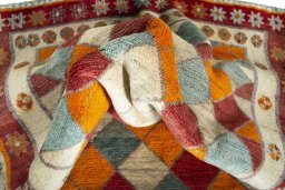 Corner detail of 2000s Persian Gabbeh rug showing border pattern and Wool pile