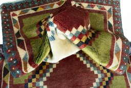 Corner detail of 2000s Persian Gabbeh rug showing border pattern and Wool pile