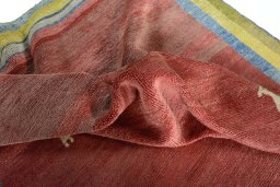 Corner detail of 2000s Persian Gabbeh rug showing border pattern and Wool pile
