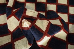 Corner detail of 2000s Persian Gabbeh rug showing border pattern and Wool pile