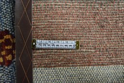 Corner detail of 2000s Persian Gabbeh rug showing border pattern and Wool pile