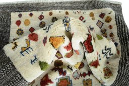 Corner detail of 2000s Persian Gabbeh rug showing border pattern and Wool pile