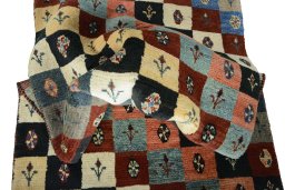 Corner detail of 2000s Persian Gabbeh rug showing border pattern and Wool pile