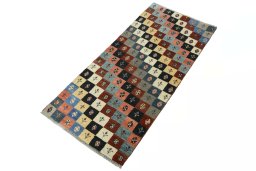 Corner detail of 2000s Persian Gabbeh rug showing border pattern and Wool pile