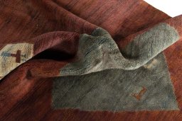 Corner detail of 2000s Persian Gabbeh rug showing border pattern and Wool pile