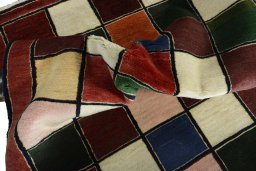 Corner detail of 2000s Persian Gabbeh rug showing border pattern and Wool pile