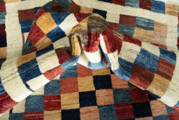 Corner detail of 2000s Persian Gabbeh rug showing border pattern and Wool pile