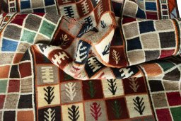 Corner detail of 2000s Persian Gabbeh rug showing border pattern and Wool pile