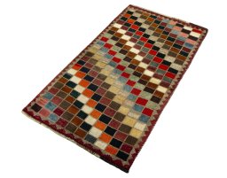 Corner detail of 2000s Persian Gabbeh rug showing border pattern and Wool pile